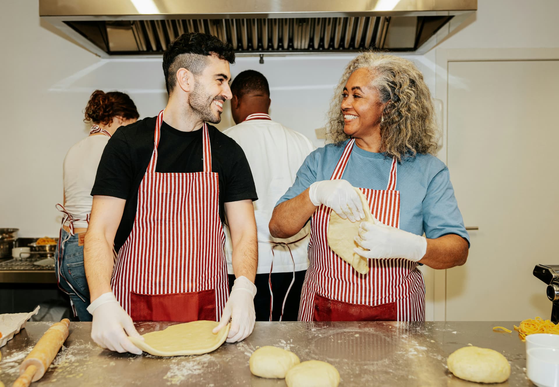 Travelers making fresh pasta together in a cooking class