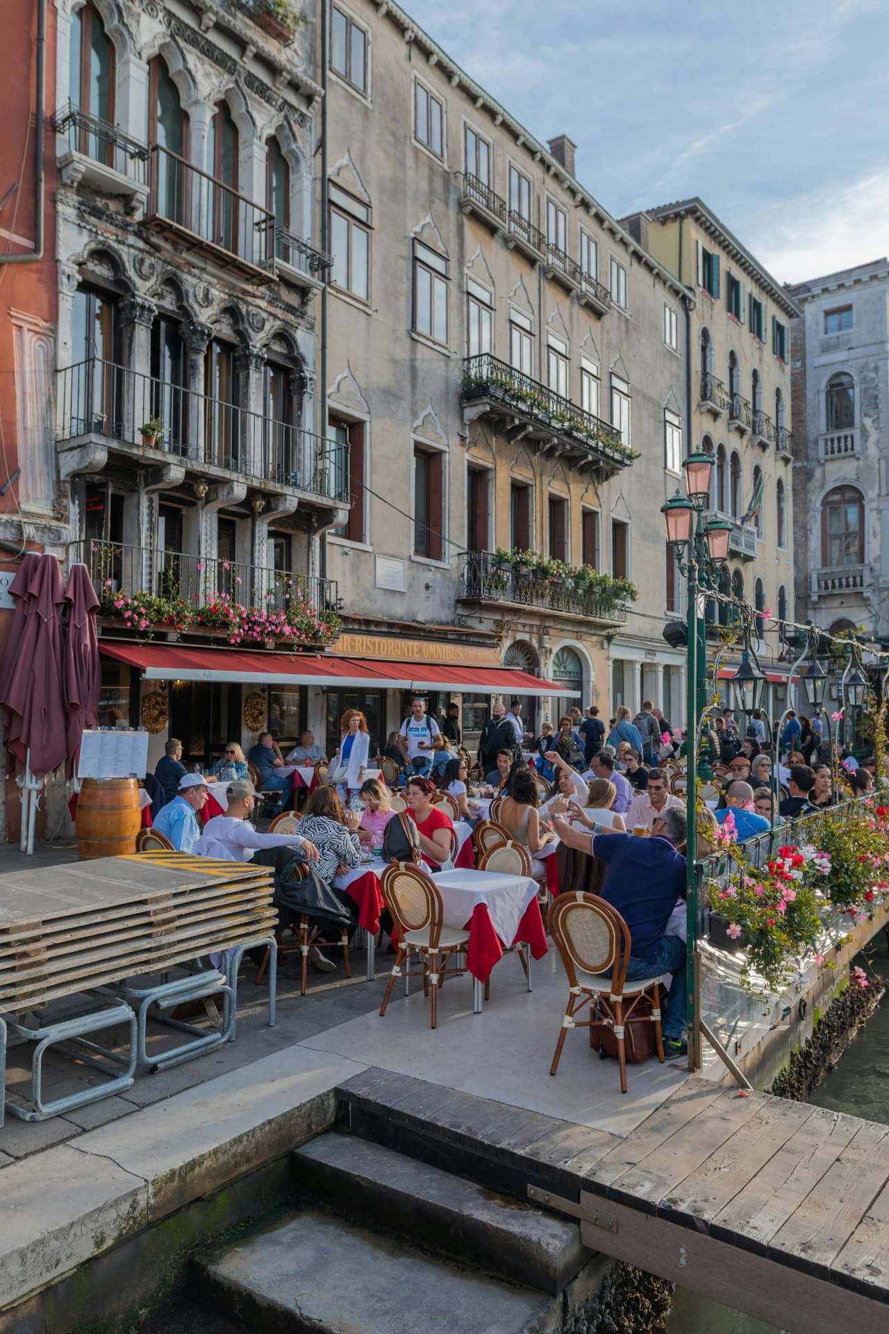 Travelers enjoying a café terrace along the water