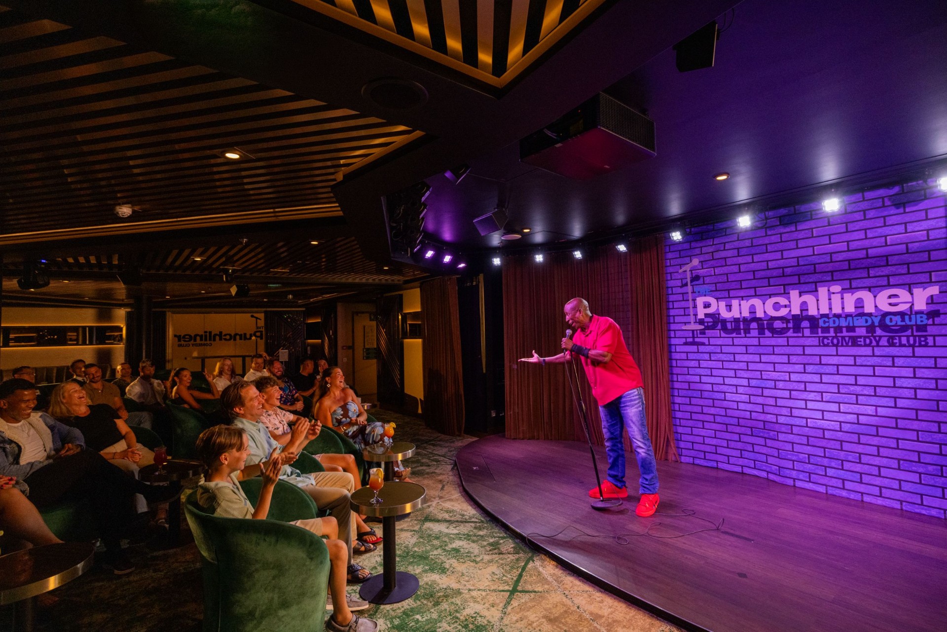 Comedian on stage at the Punchliner Comedy Club with a laughing audience