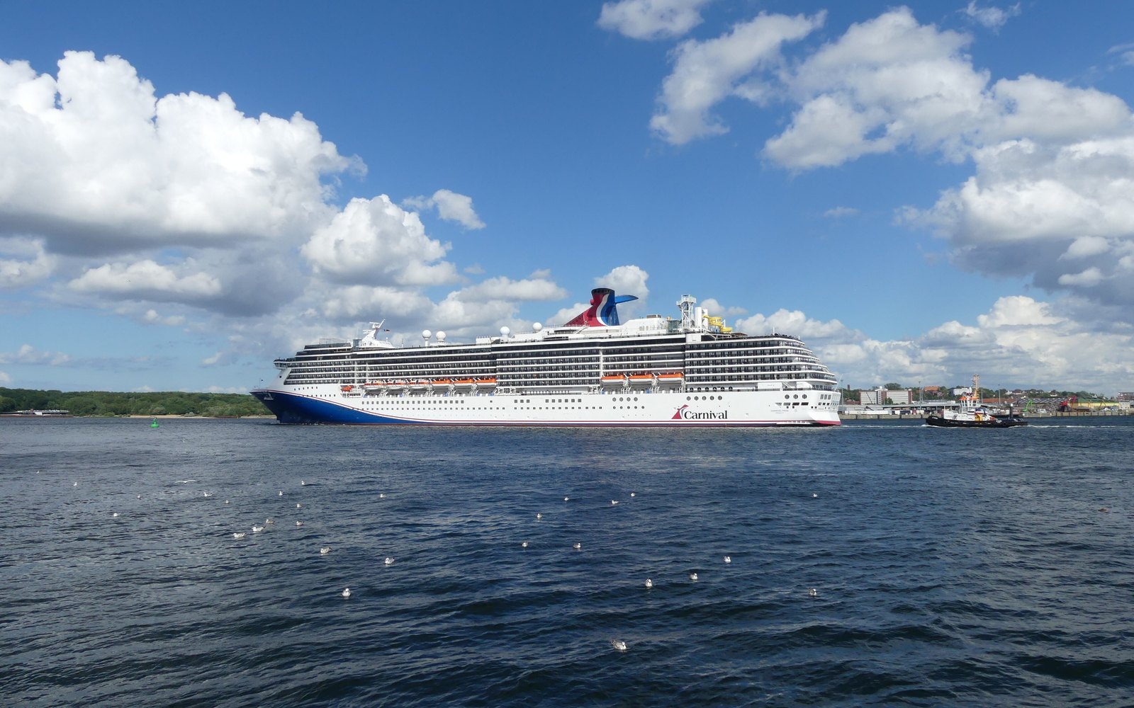 Carnival Pride cruise ship sailing at sea on a bright blue day